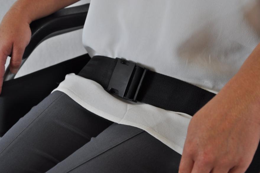 a person sitting in a chair with a belt around their waist